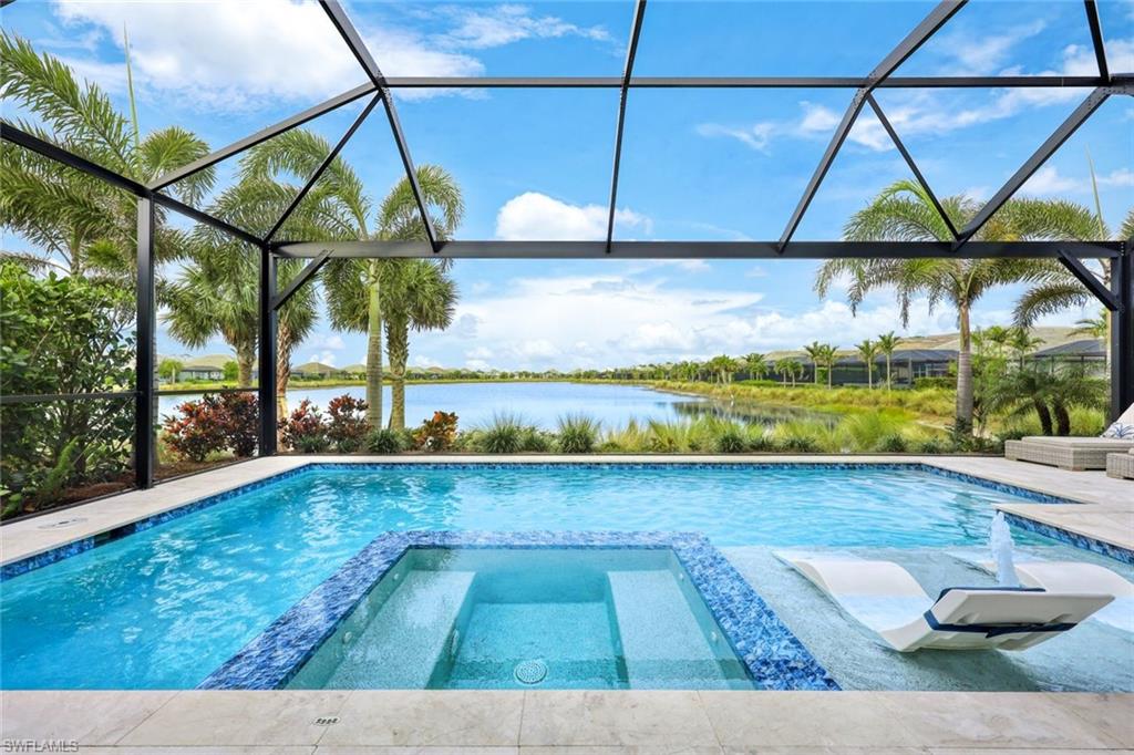 View of pool with glass enclosure, a water view, and an in ground hot tub