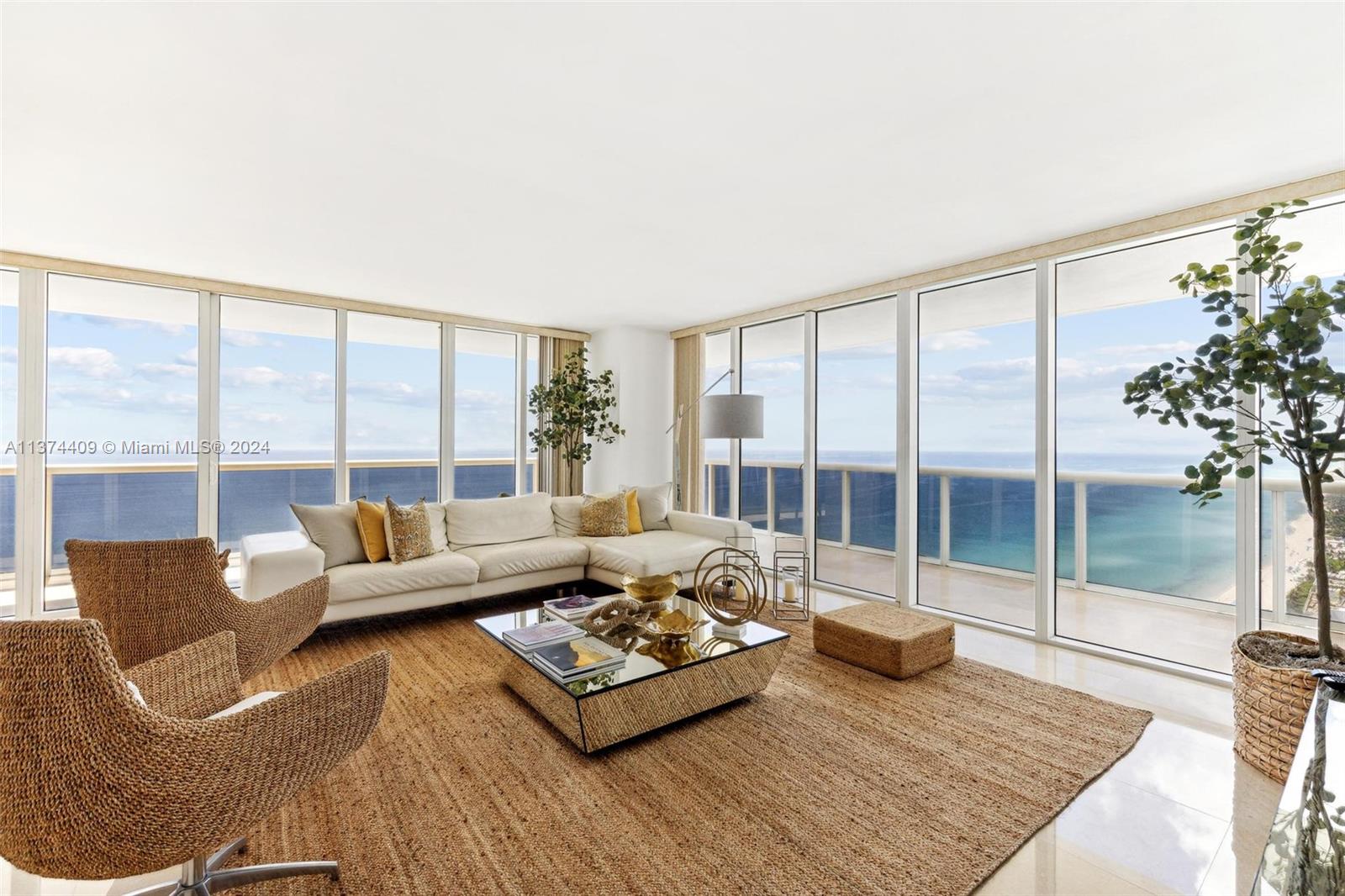 a living room with furniture and a floor to ceiling window