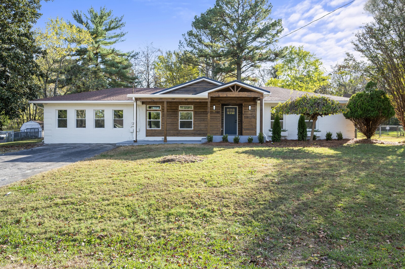 a front view of a house with a garden and trees