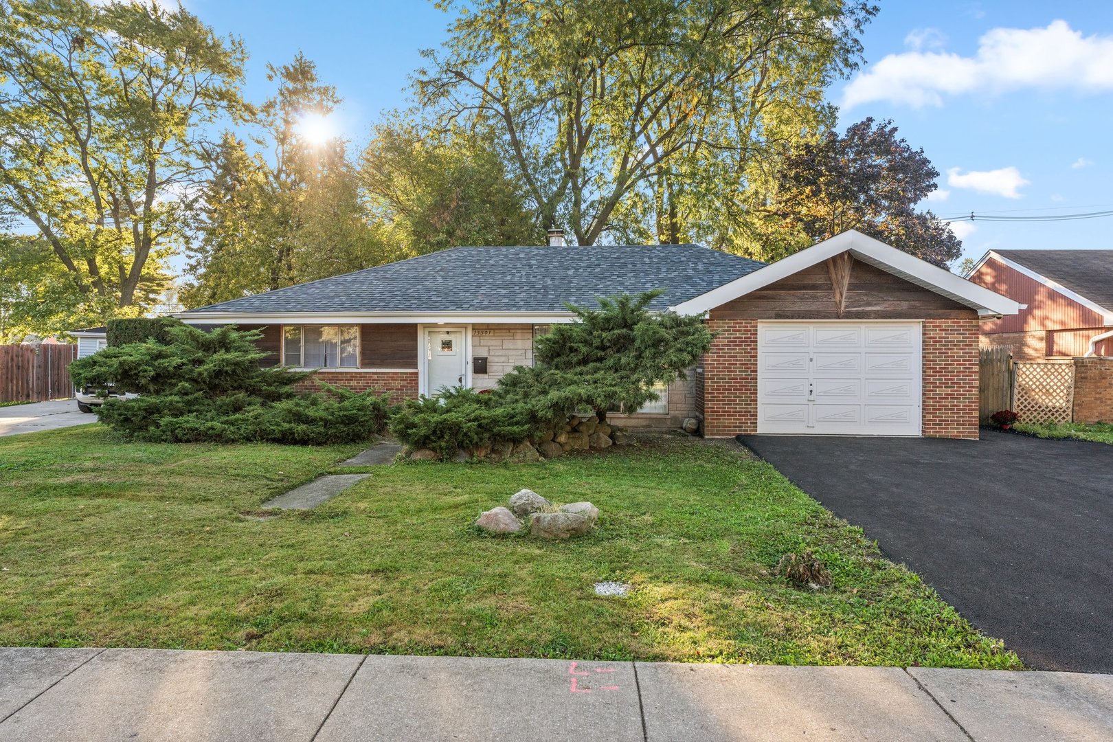 a front view of a house with a yard and trees