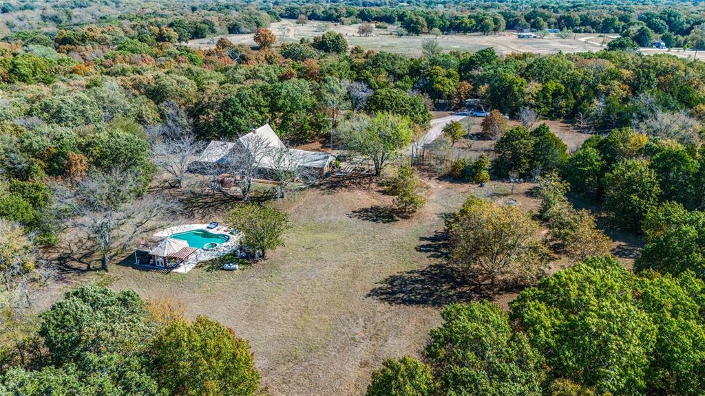 an aerial view of a house with a yard and lake view