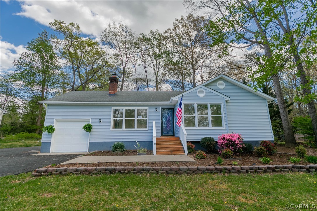 a front view of house with yard and trees in the background