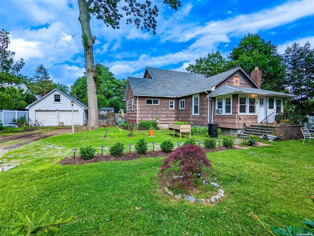 View of front of home with an outbuilding, a garage, and a front yard