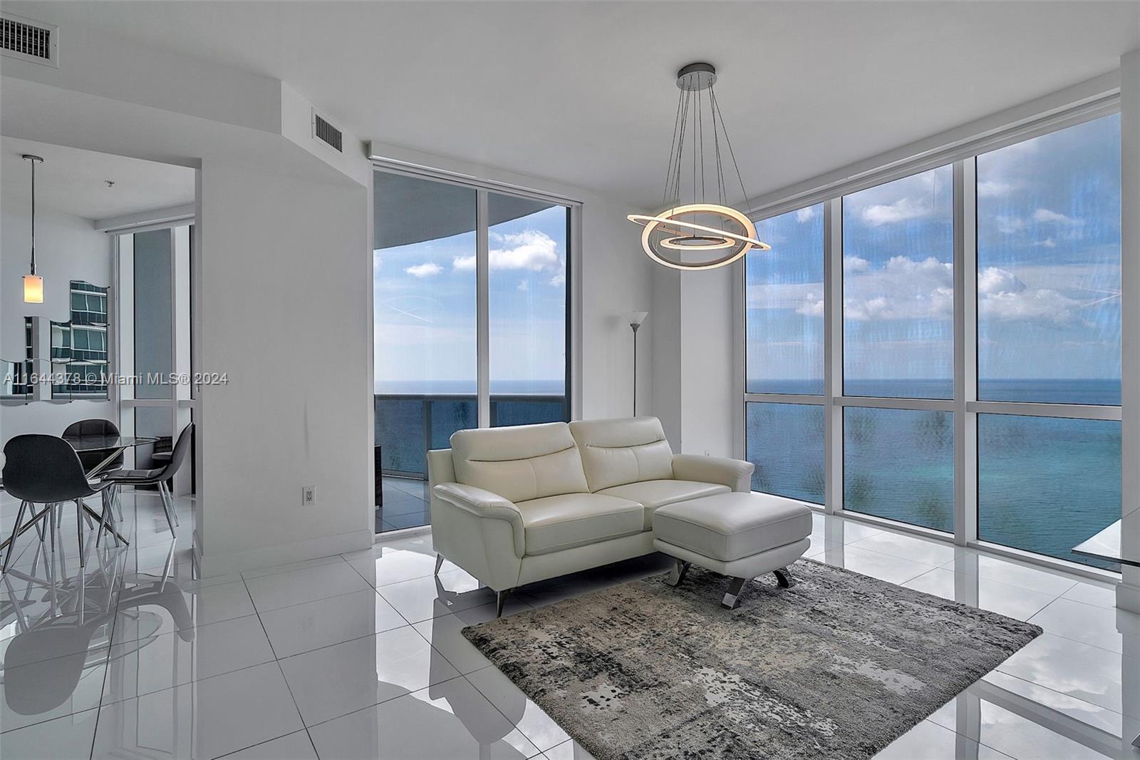 a living room with furniture a rug and a chandelier