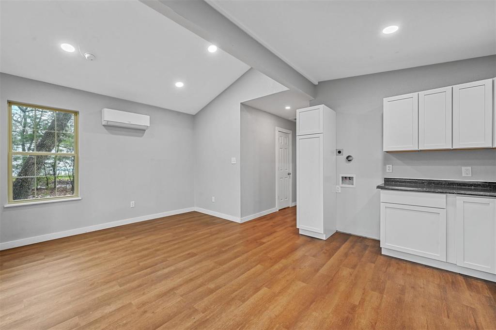 a view of a kitchen with wooden floor and a window