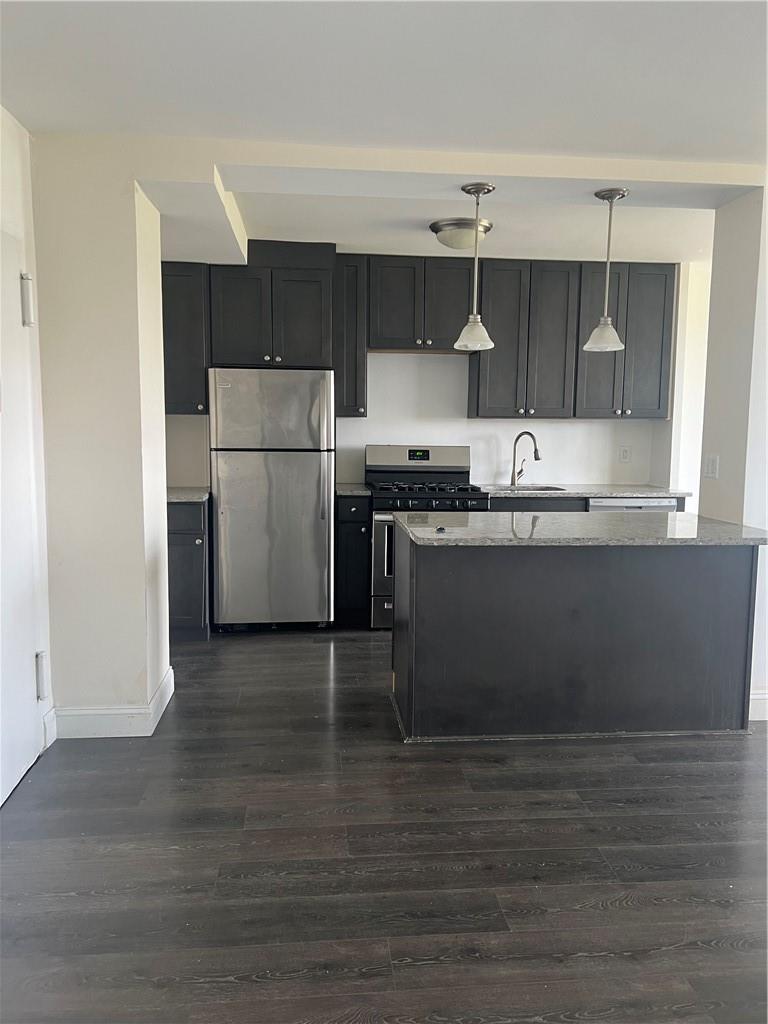 a kitchen with stainless steel appliances a sink a stove a refrigerator and cabinets