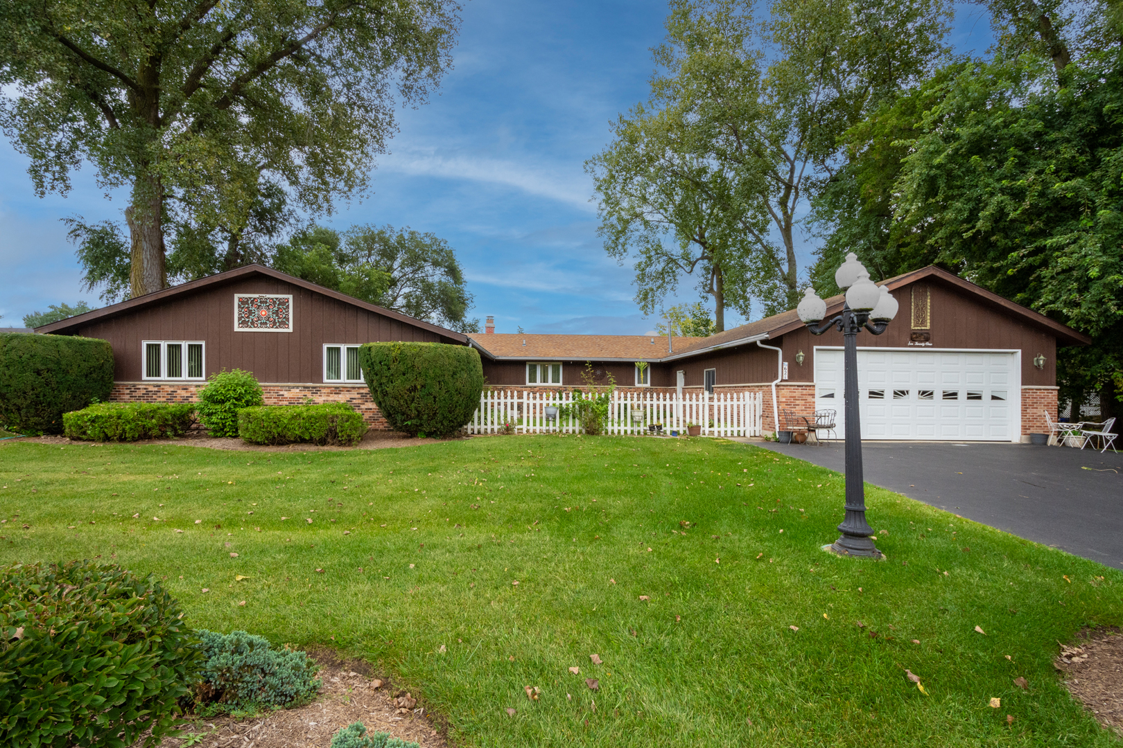 a view of a big house with a big yard and large trees