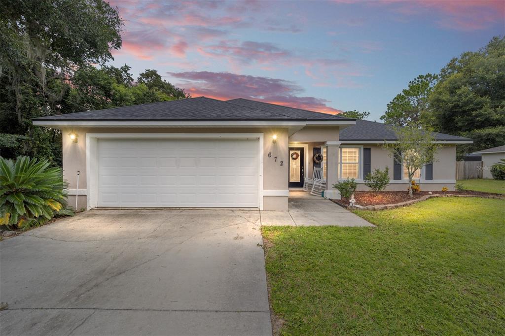 a front view of a house with yard patio and green space