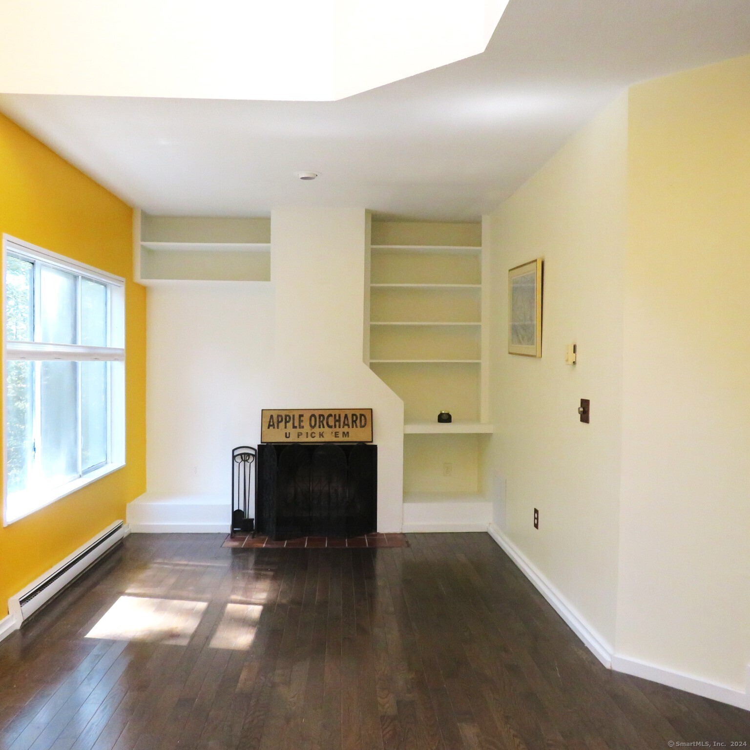 a living room with a fireplace and a large window