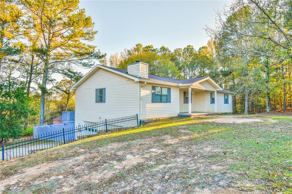 a view of a house with backyard and trees