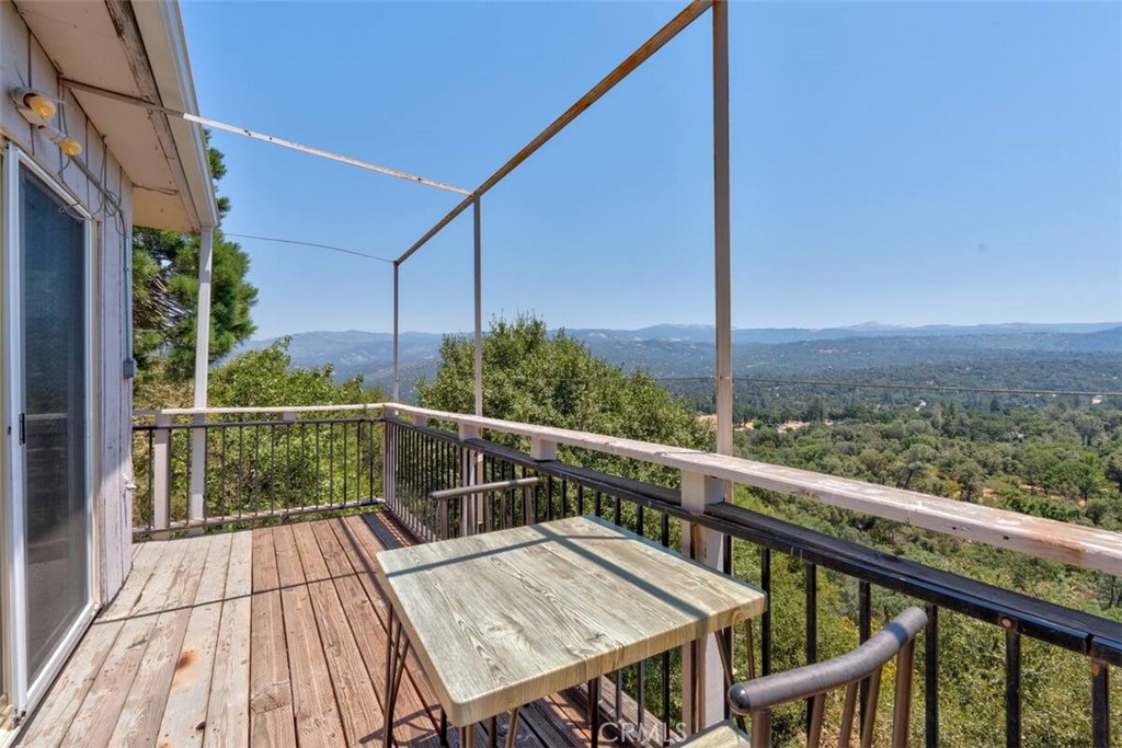 a view of a balcony with wooden floor and iron stairs