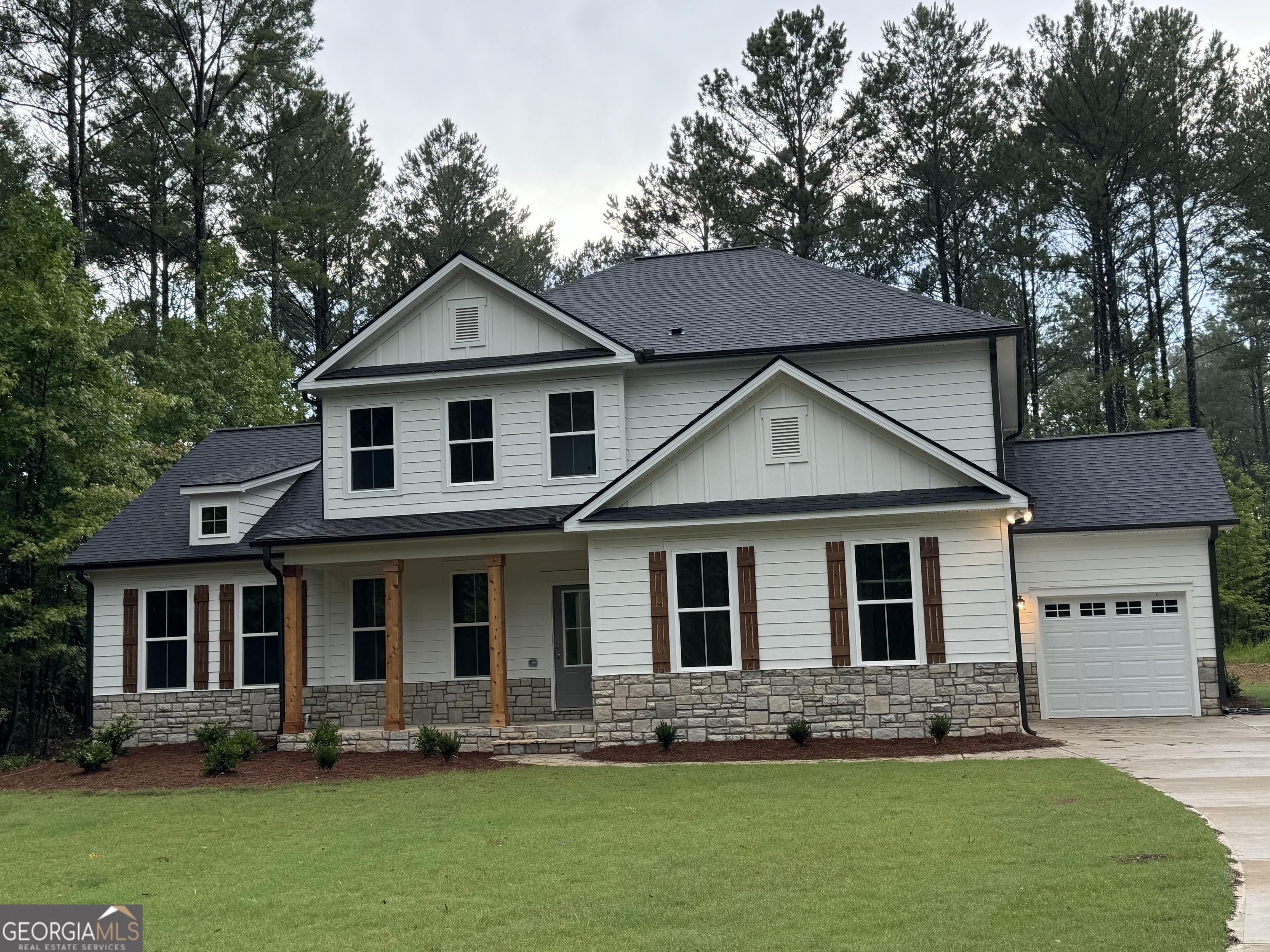 a front view of a house with a yard and trees