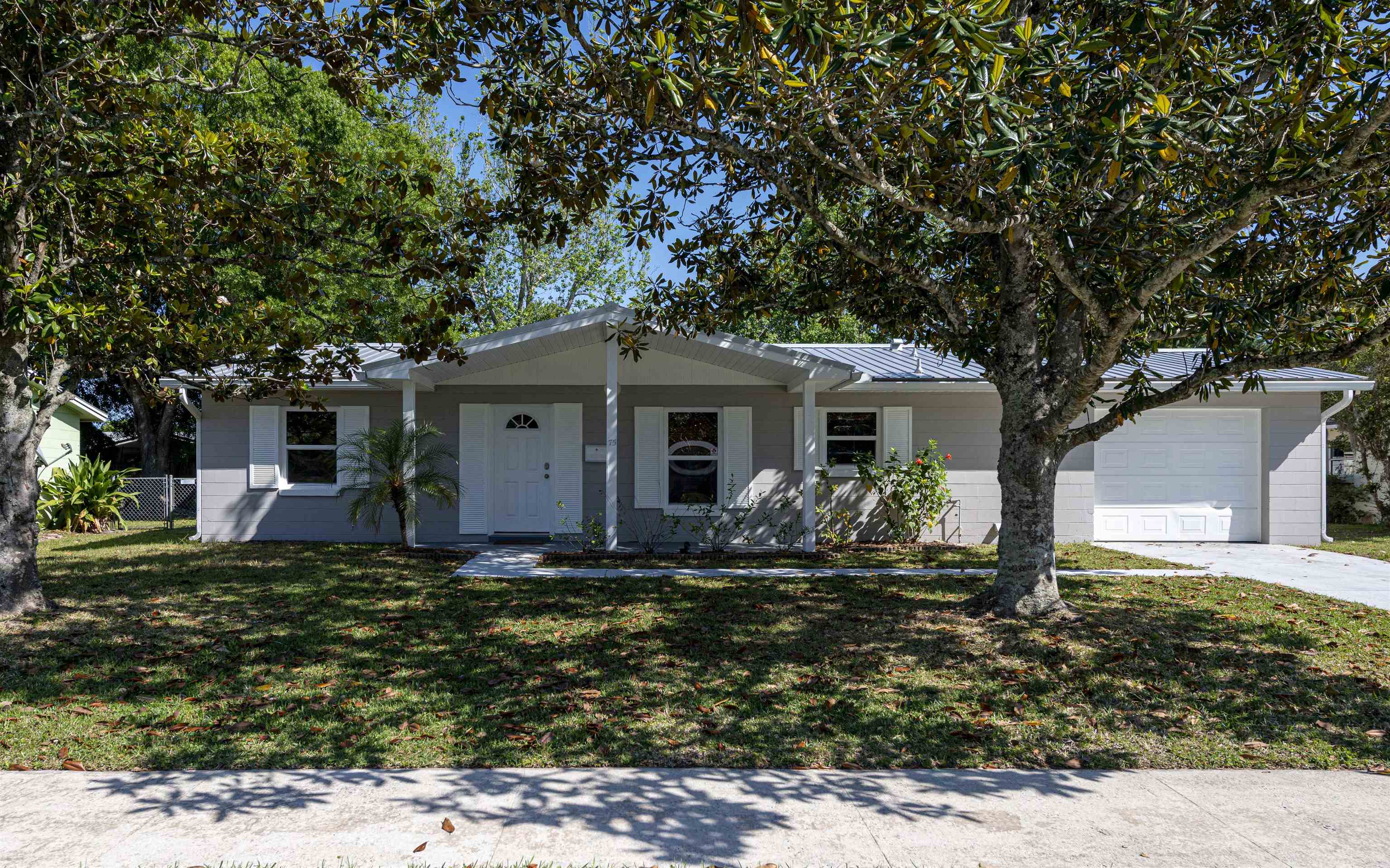 a front view of house with yard and trees around