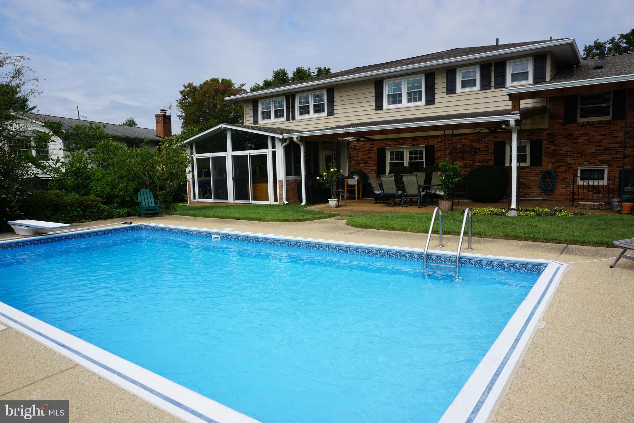 a view of pool with umbrella and chairs