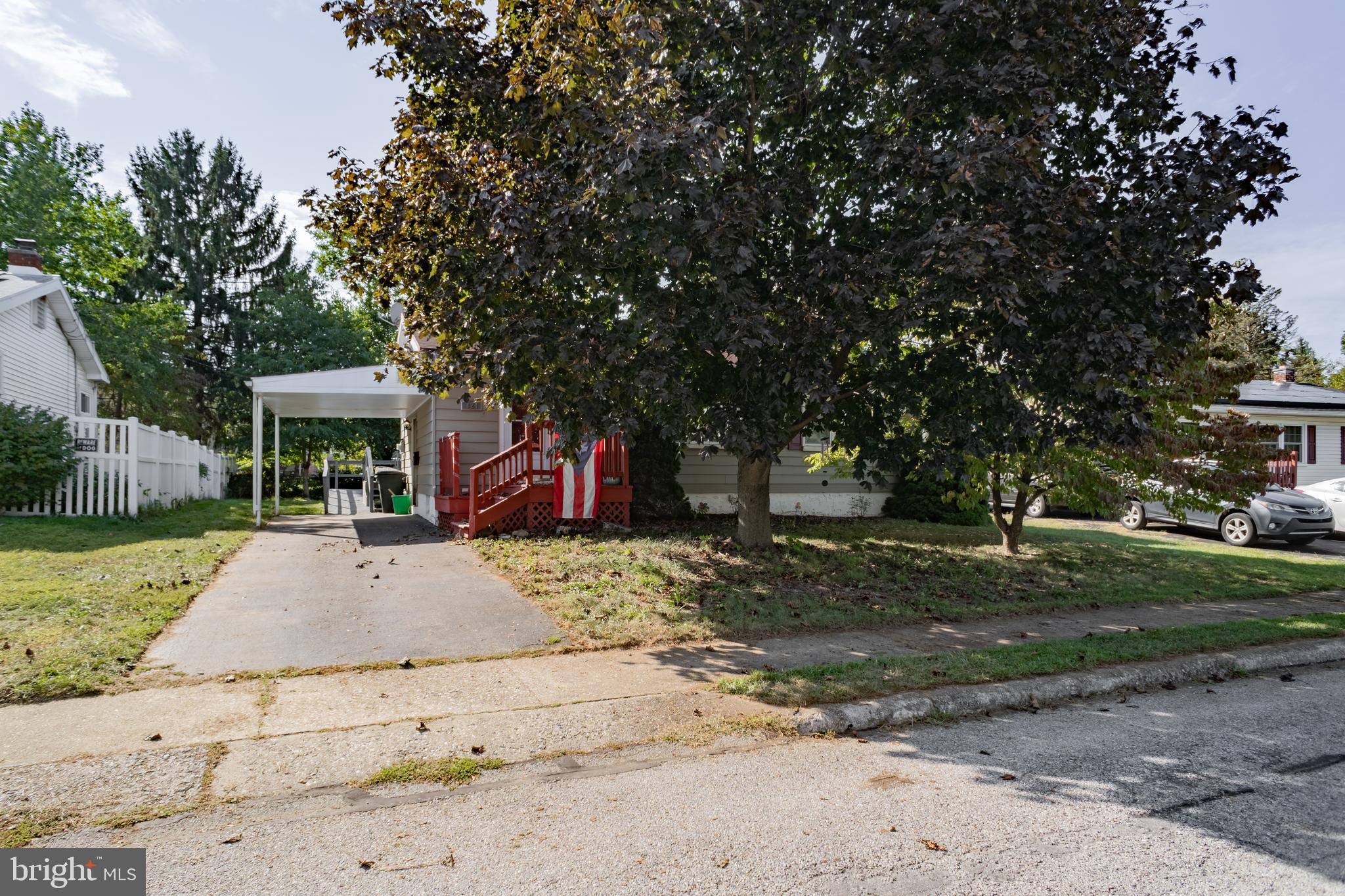 a view of a house with a yard and large tree