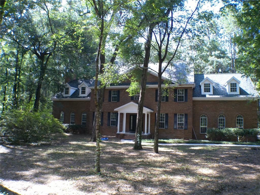 a front view of a house with a tree