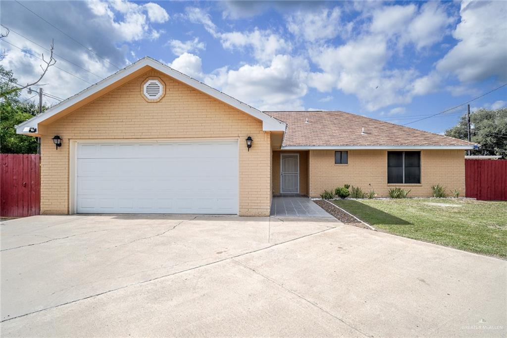 Ranch-style home with a front lawn and a garage