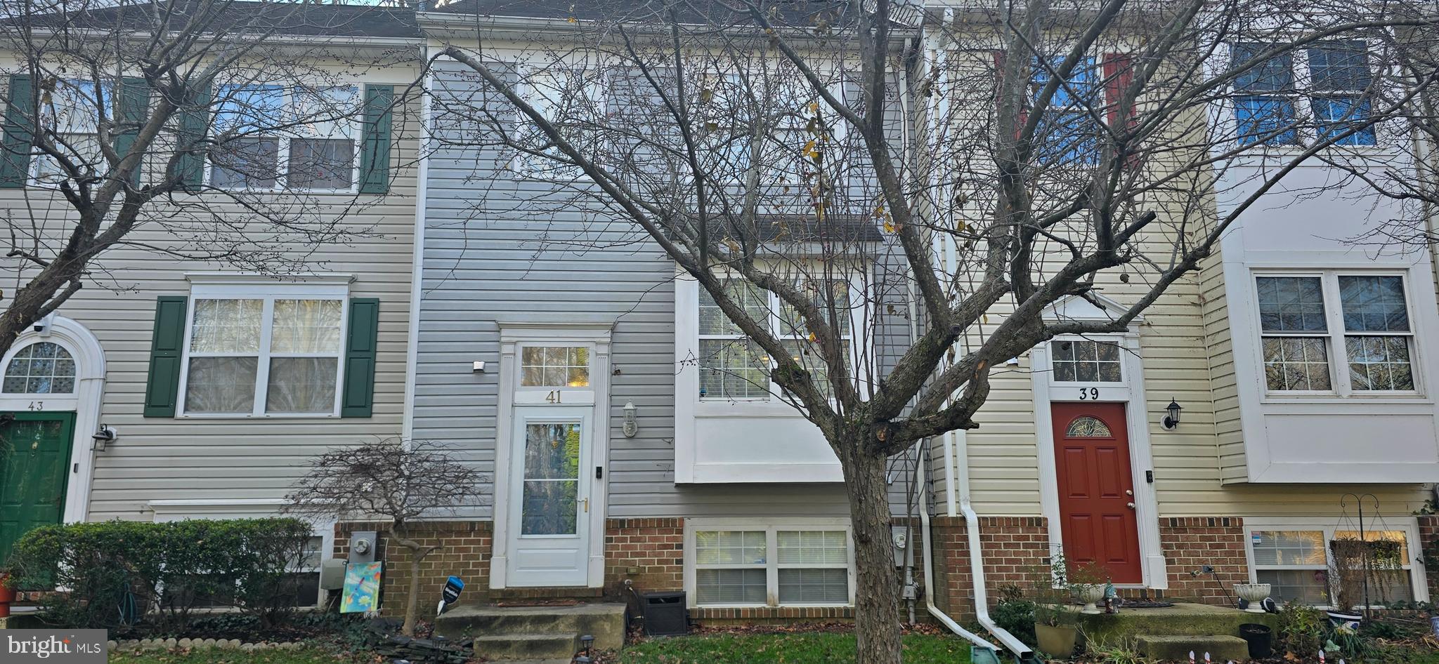 a front view of a house with a tree