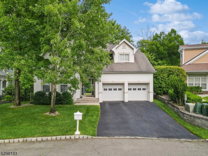 a front view of a house with a yard and trees