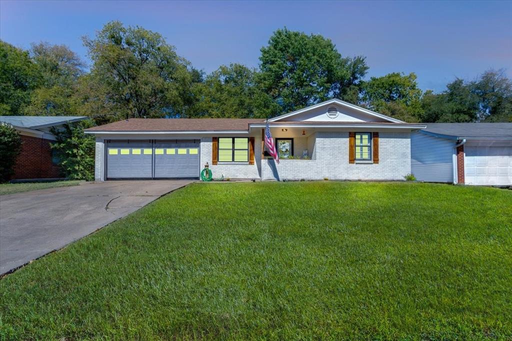 a front view of a house with a garden and yard