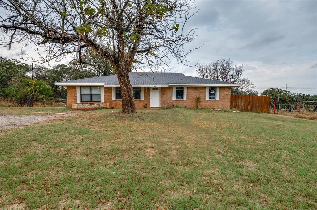 a front view of house with yard and trees around