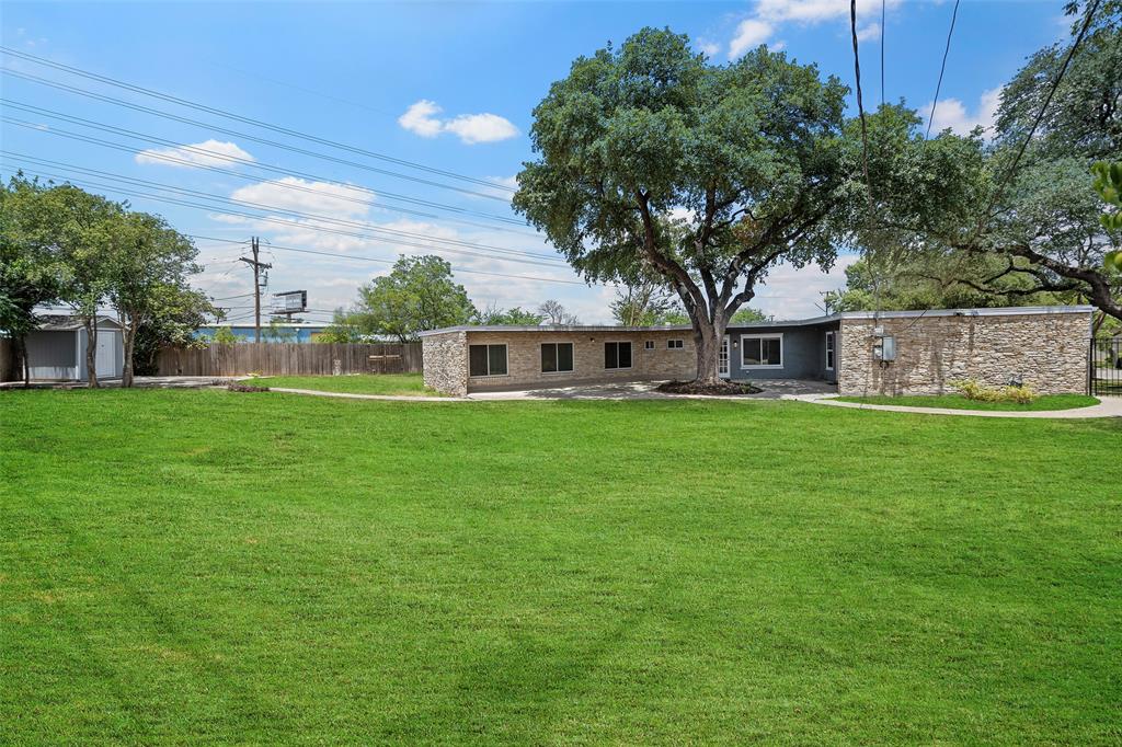 a view of a house with a big yard and large trees