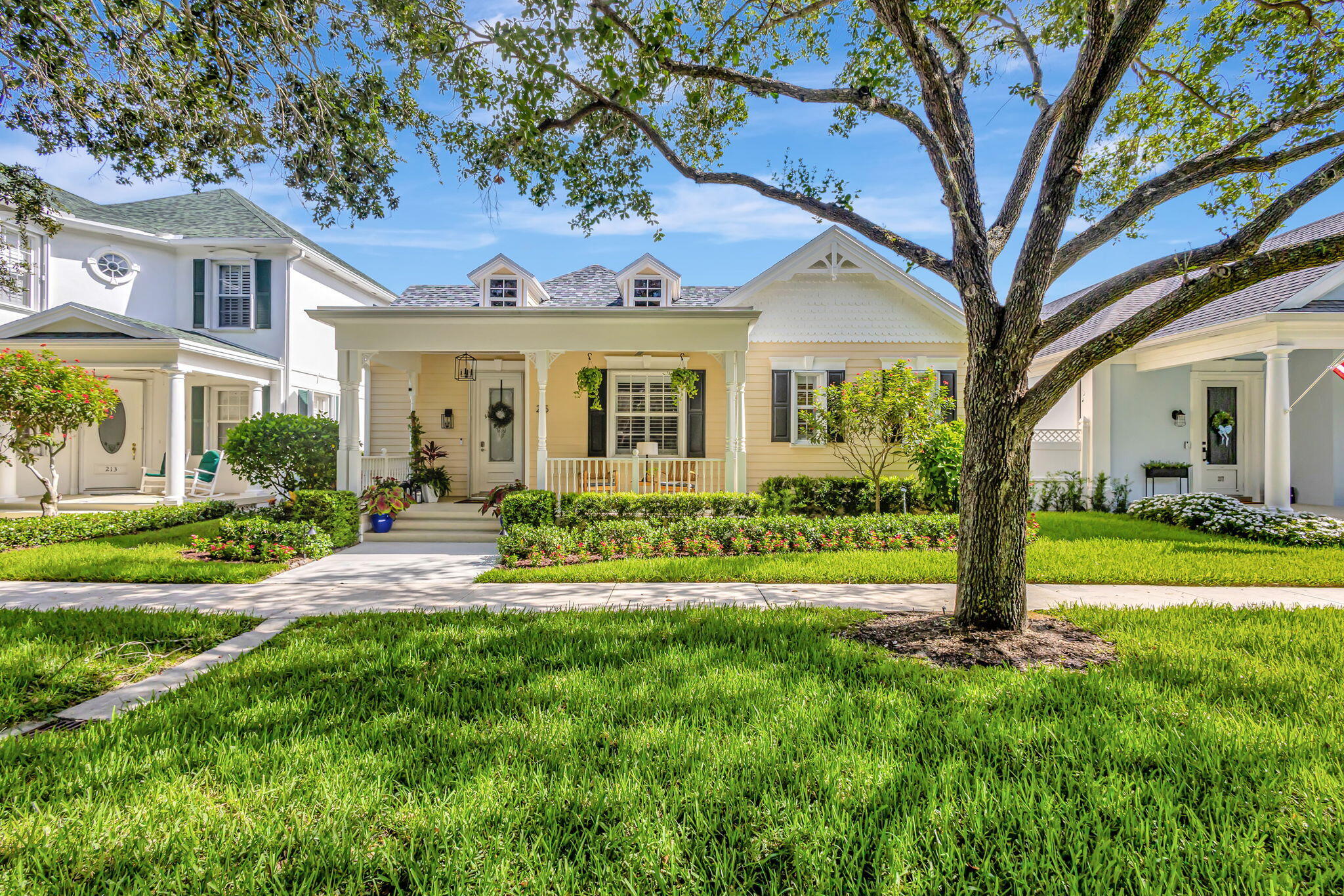 a front view of a house with a yard and trees