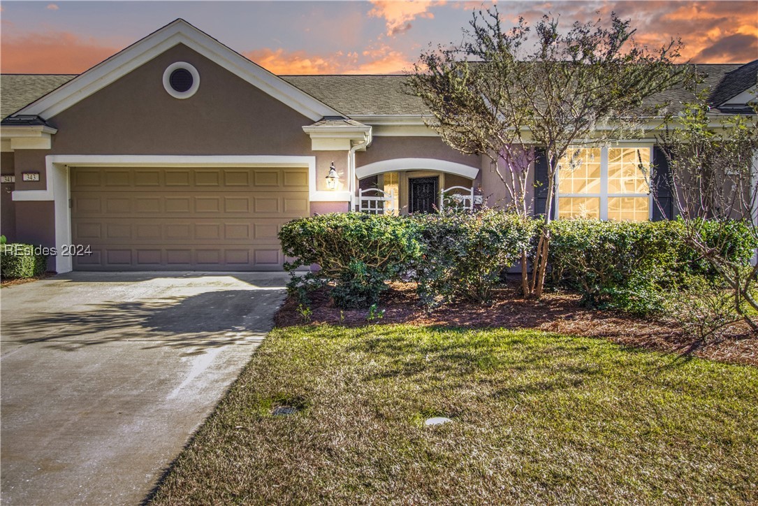 View of front facade with a garage and a yard