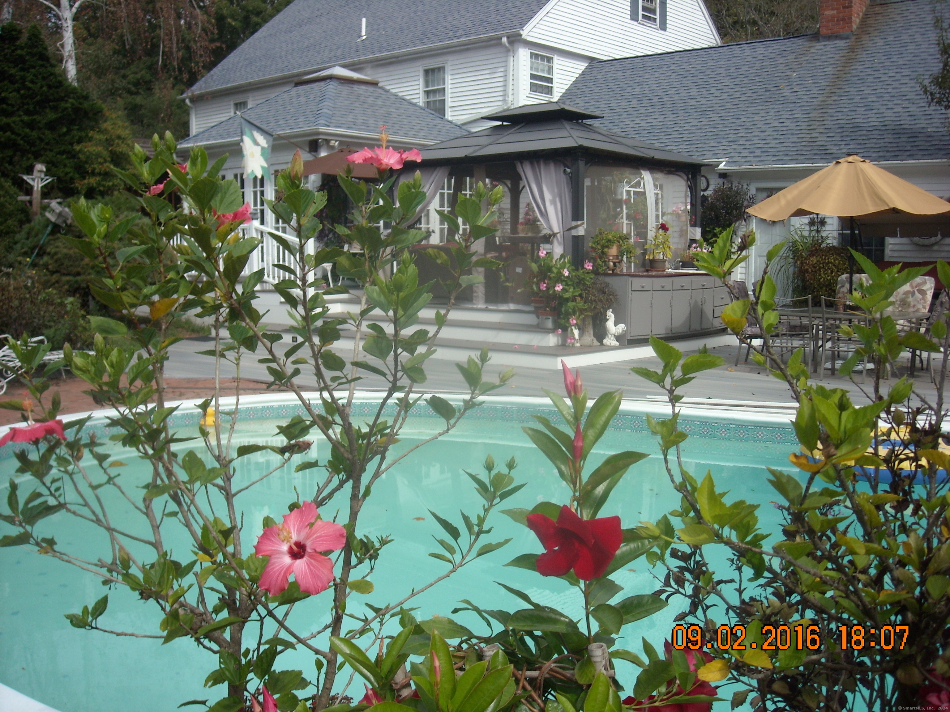 a backyard of a house with a garden and outdoor seating