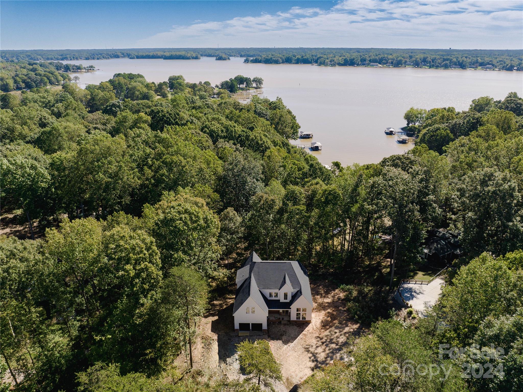 an aerial view of a house with a yard and lake view