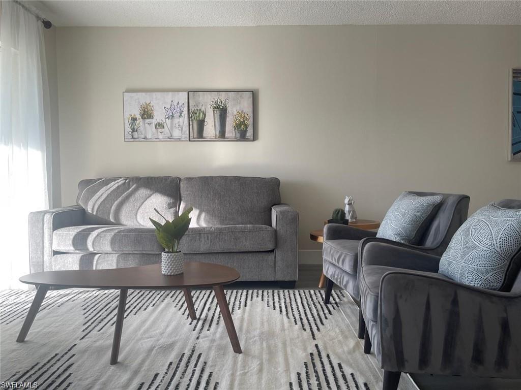 Living room featuring wood-type flooring and a textured ceiling