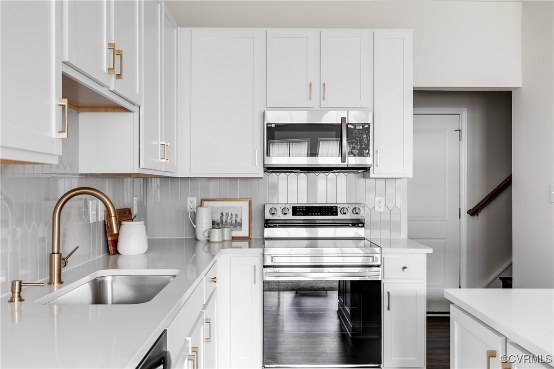 a kitchen with stainless steel appliances granite countertop a sink and a stove