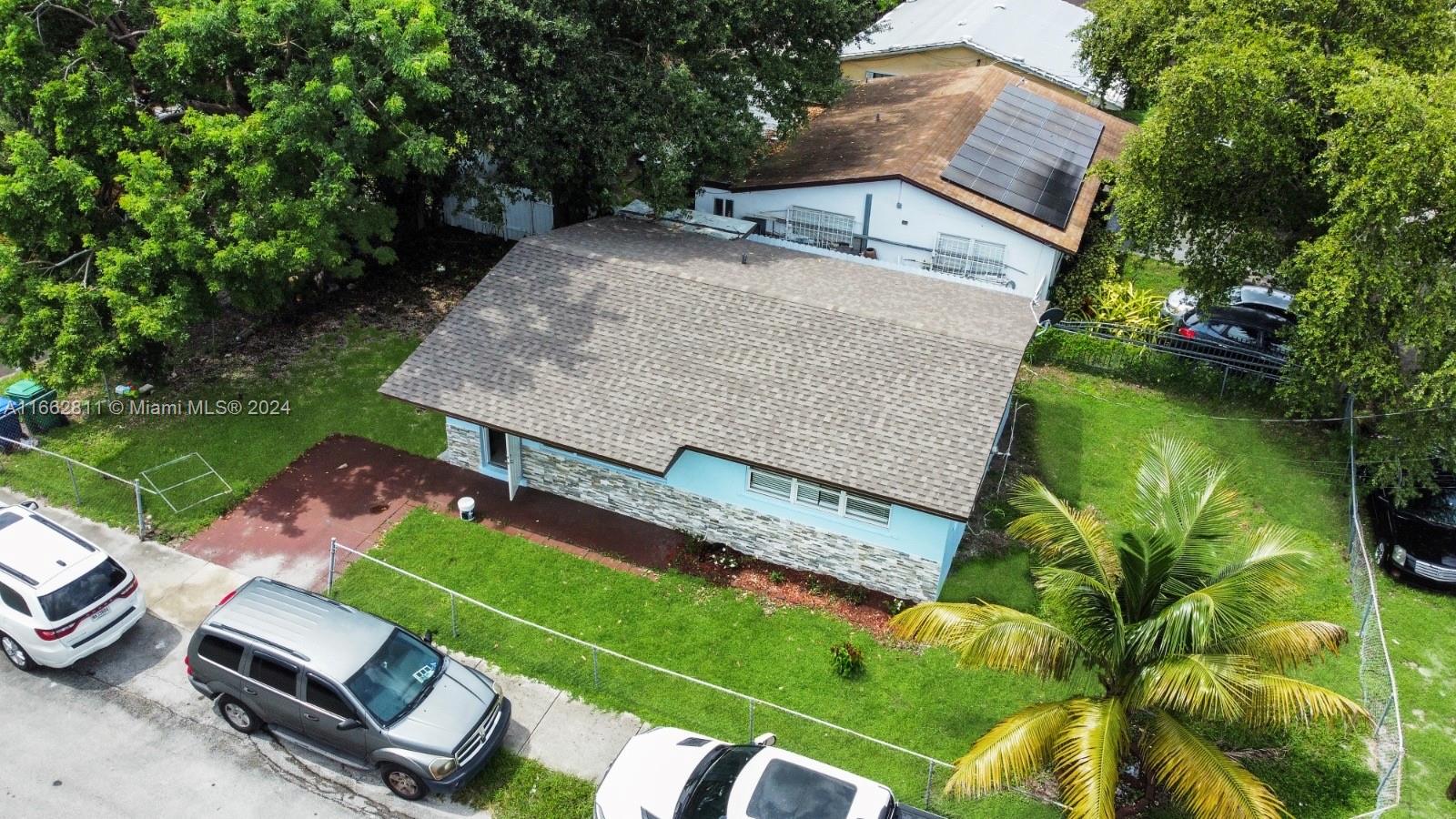 an aerial view of a house with backyard space and balcony