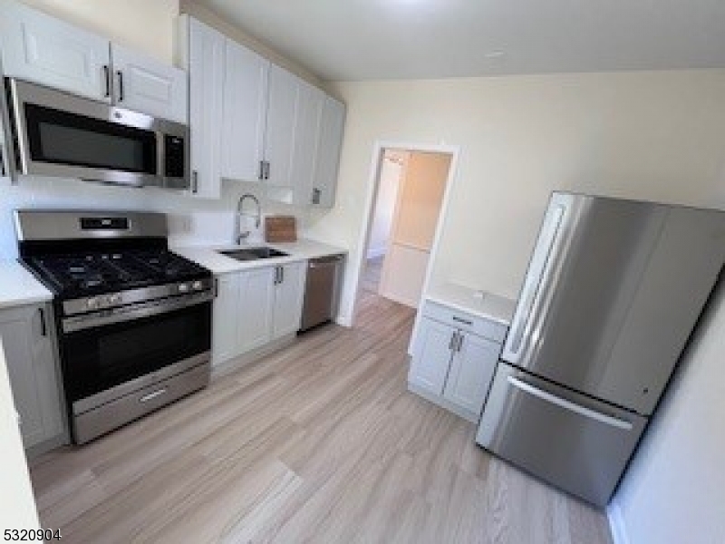 a kitchen with a refrigerator stove and wooden cabinets