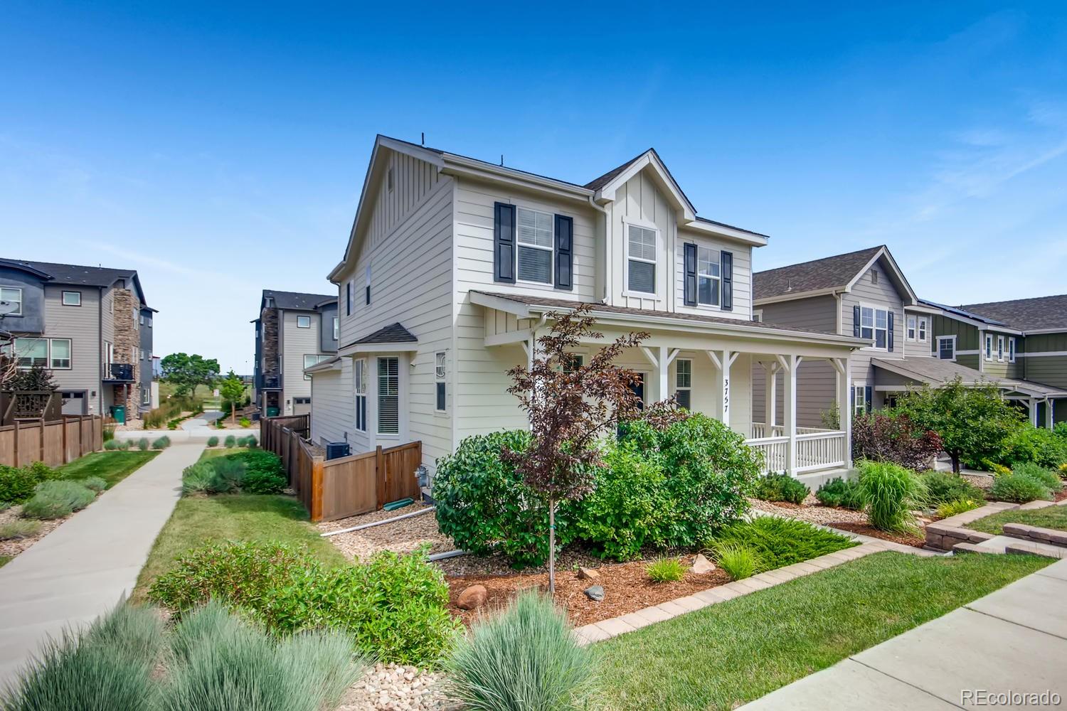 a front view of a house with a yard and potted plants