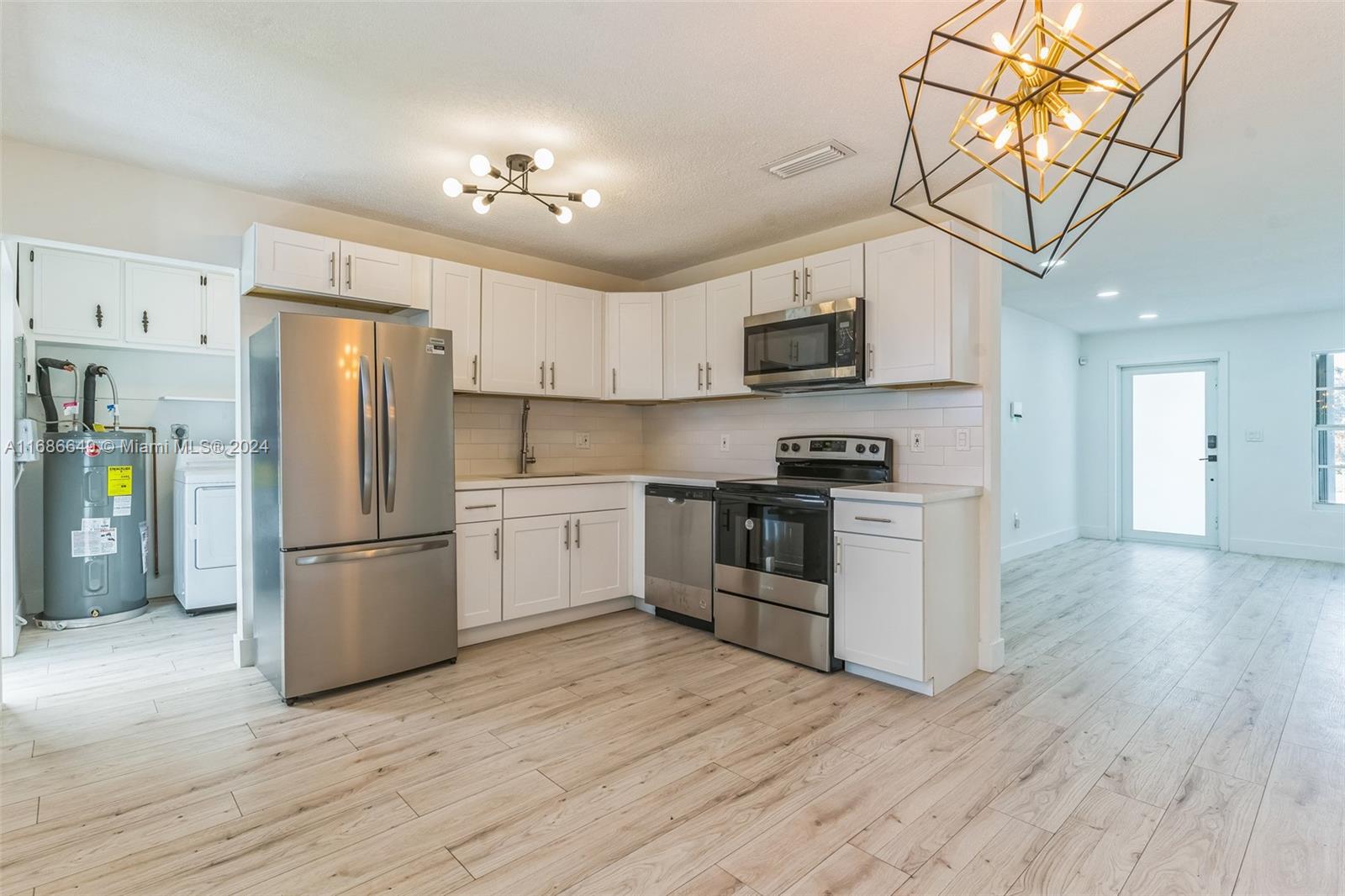 a kitchen with a refrigerator a stove top oven a sink and cabinets