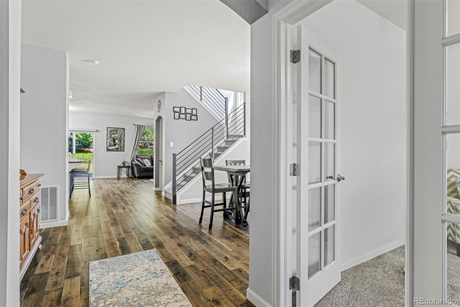 a view of a hallway with wooden floor and staircase