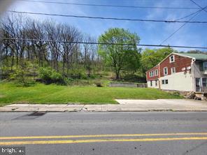 a view of a house with a yard and a large parking space