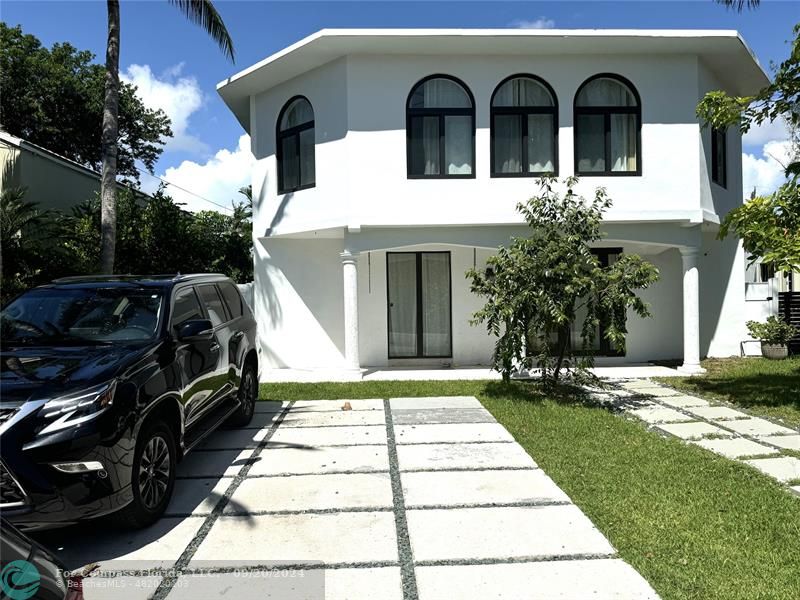 a front view of a house with a garden