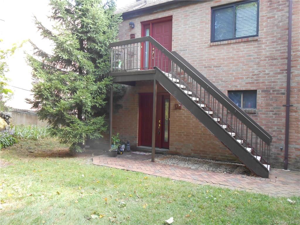 a view of house with yard and staircase