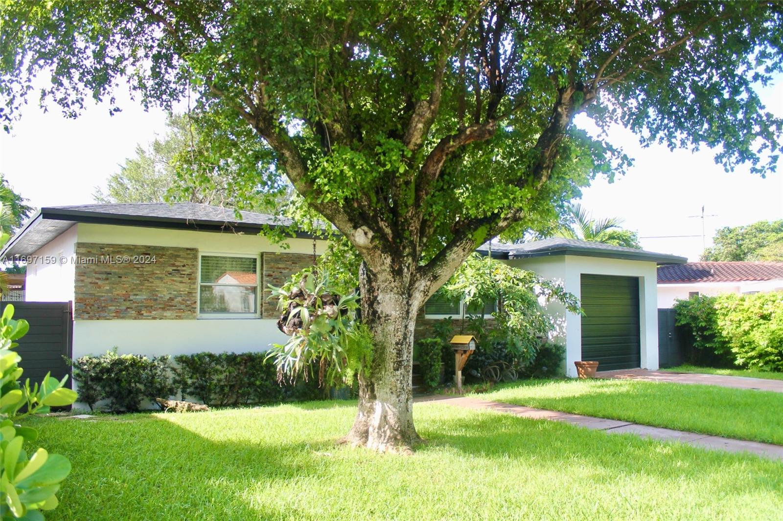 a front view of a house with a yard and trees