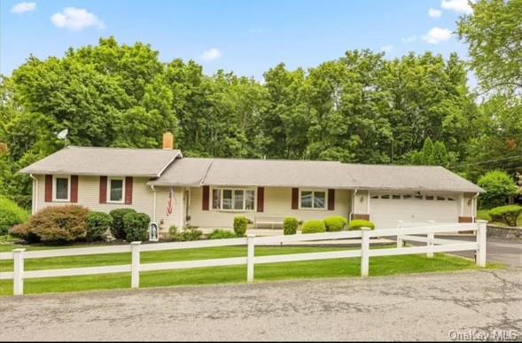 Ranch-style home featuring a front lawn and a garage