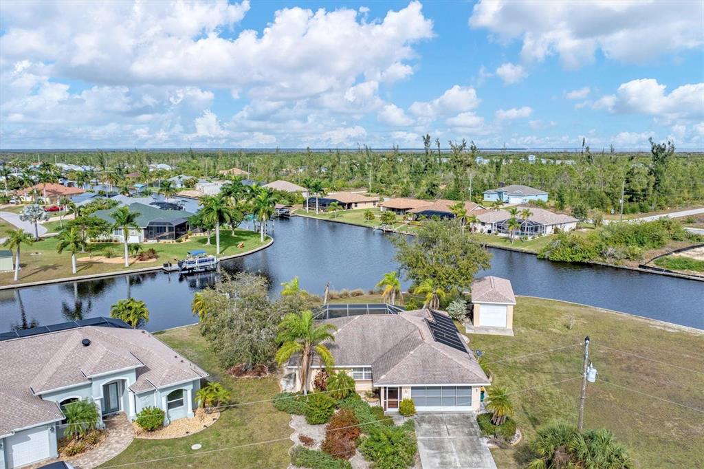 an aerial view of a house with a garden and lake view