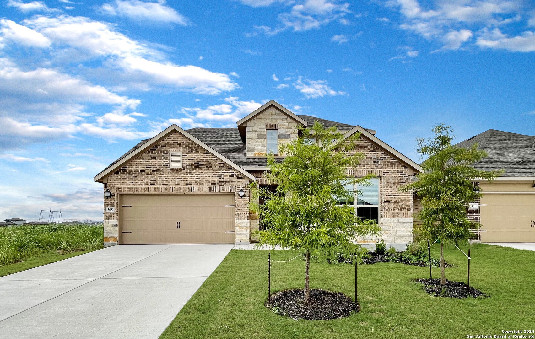 a front view of a house with a yard and trees