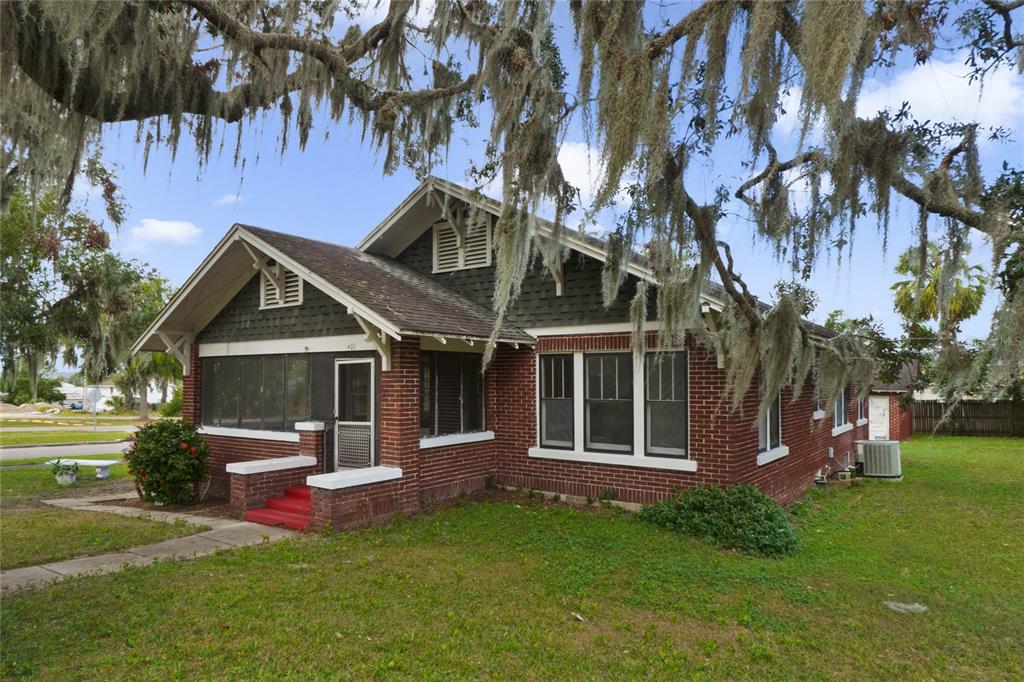 a front view of a house with a yard tree and wooden fence