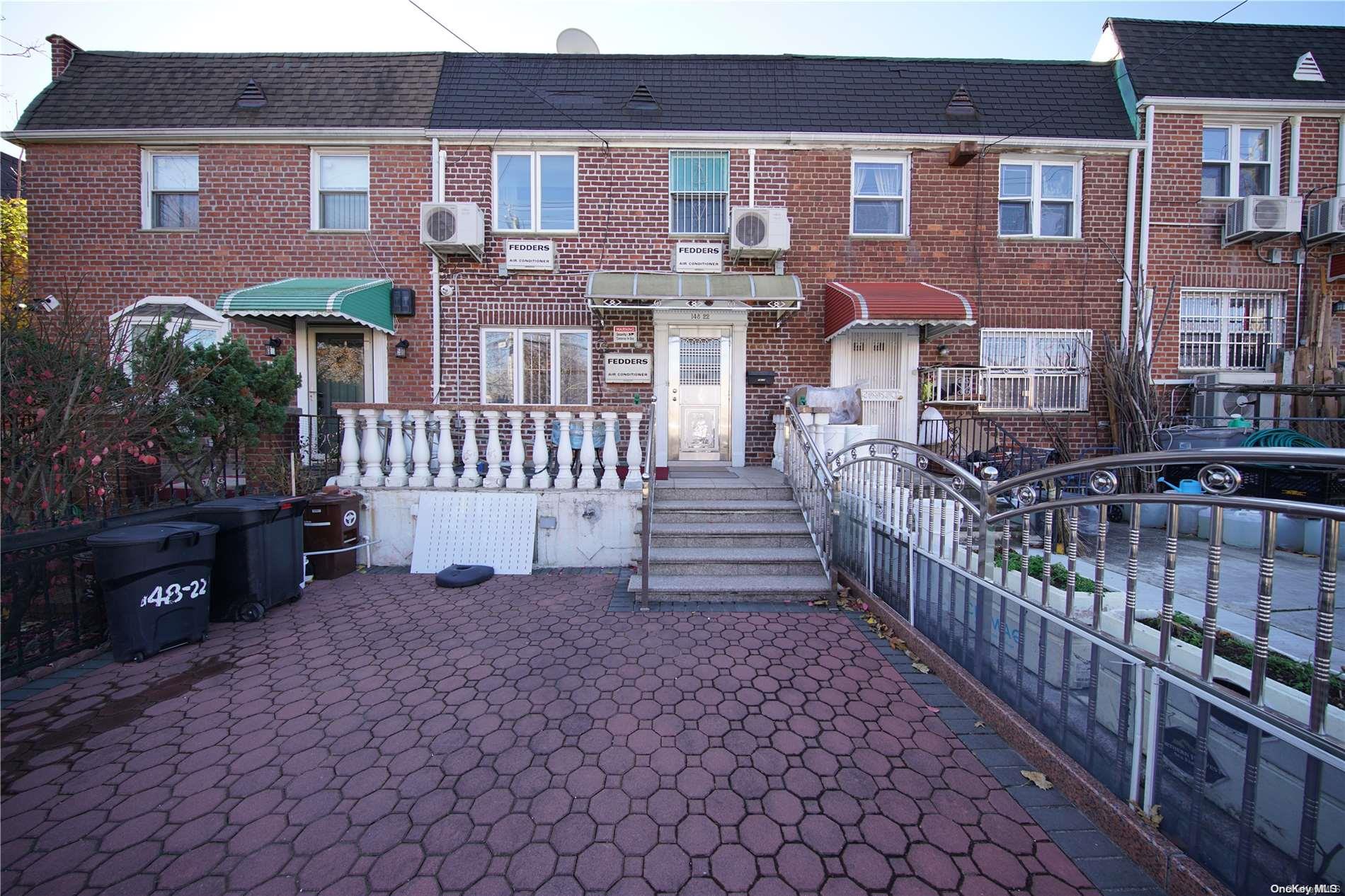 a view of a brick house with many windows and a yard