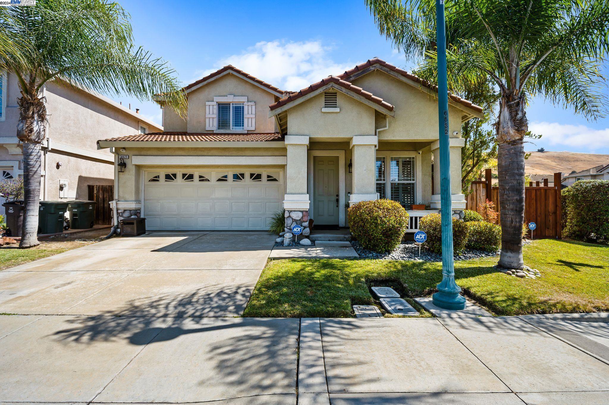 a front view of a house with garden and garage