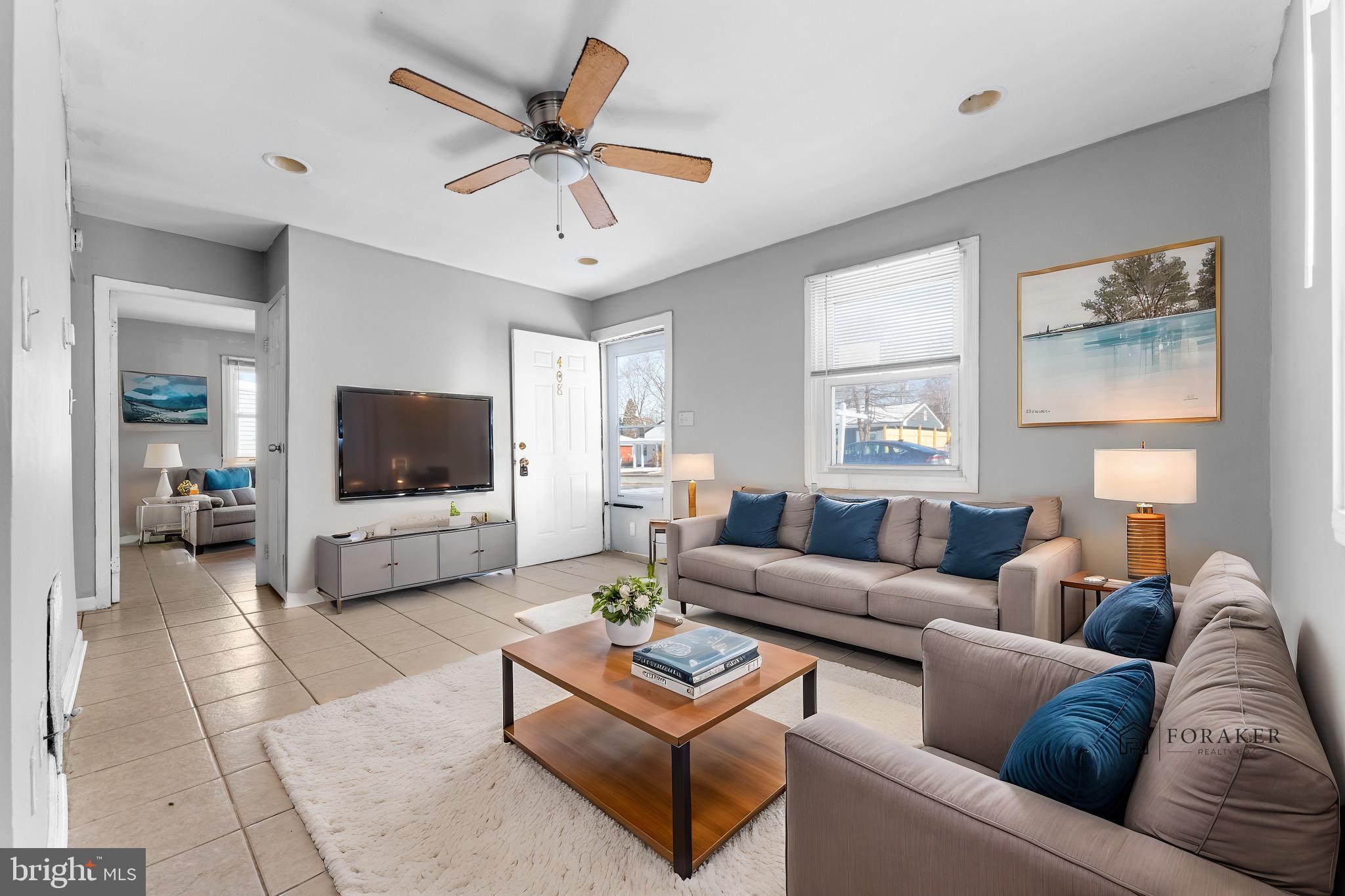 a living room with furniture a flat screen tv and a large window