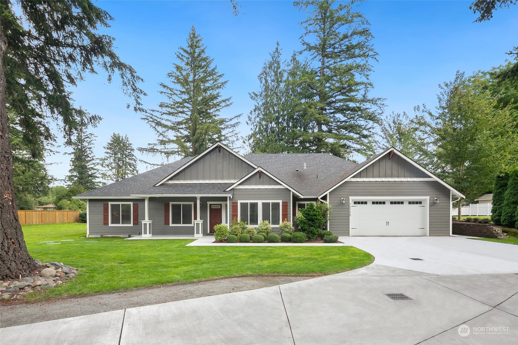 a front view of a house with a garden and trees