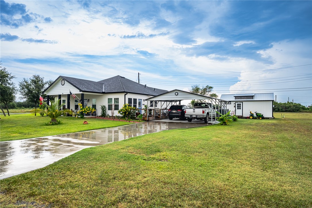 a view of a big house with a big yard and large trees